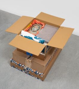 Stack of cardboard boxes filled with colorful objects