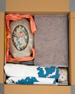 Overhead view of colorful objects arranged tightly inside of a brown box