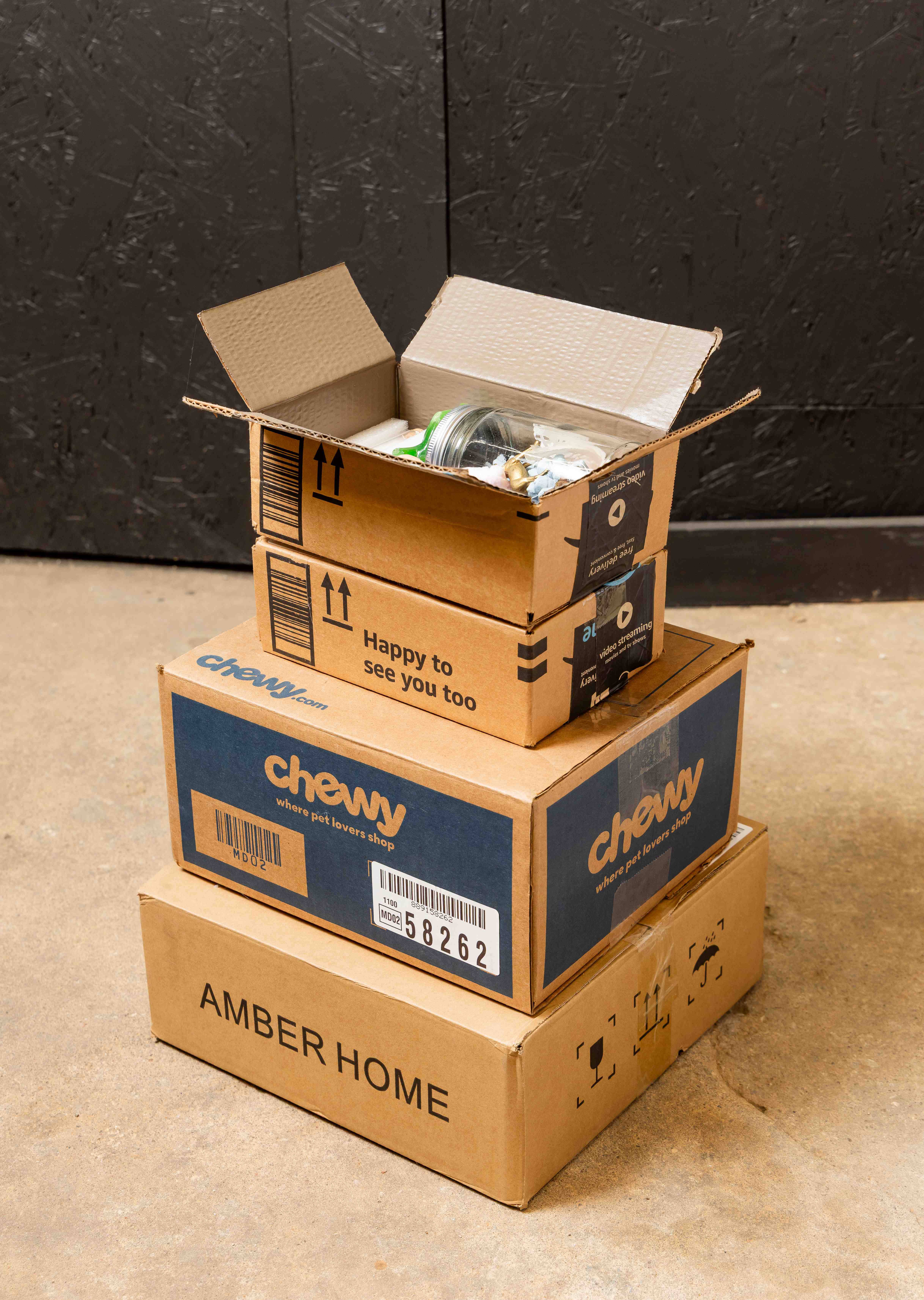 Stack of cardboard boxes with the top one open to reveal a brown interior and objects peaking out